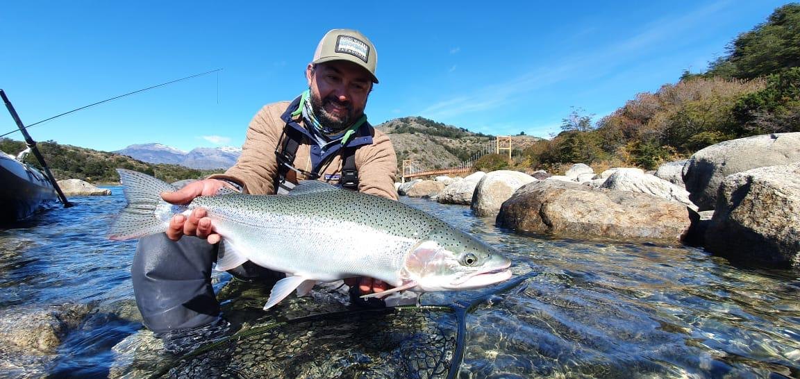 Eduardo Barrueto holding a rainbow trout at Magic Waters in Chilean Patagonia