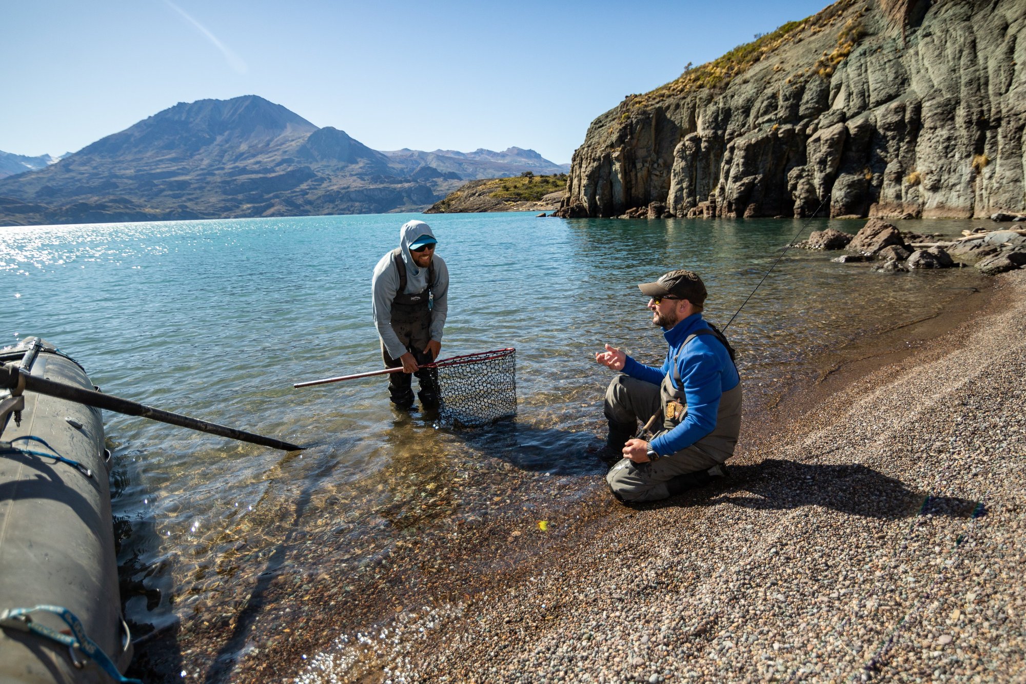 Guide and guest with a net on a clear stillwater lake in Patagonia
