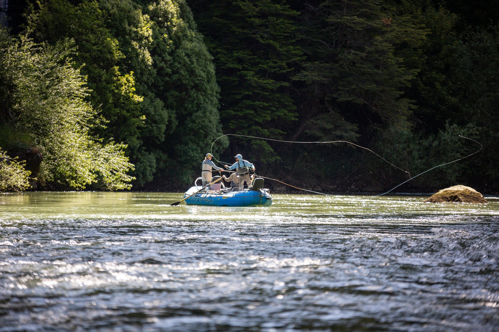 Guests casting from a raft on a Patagonia river near Coyhaique