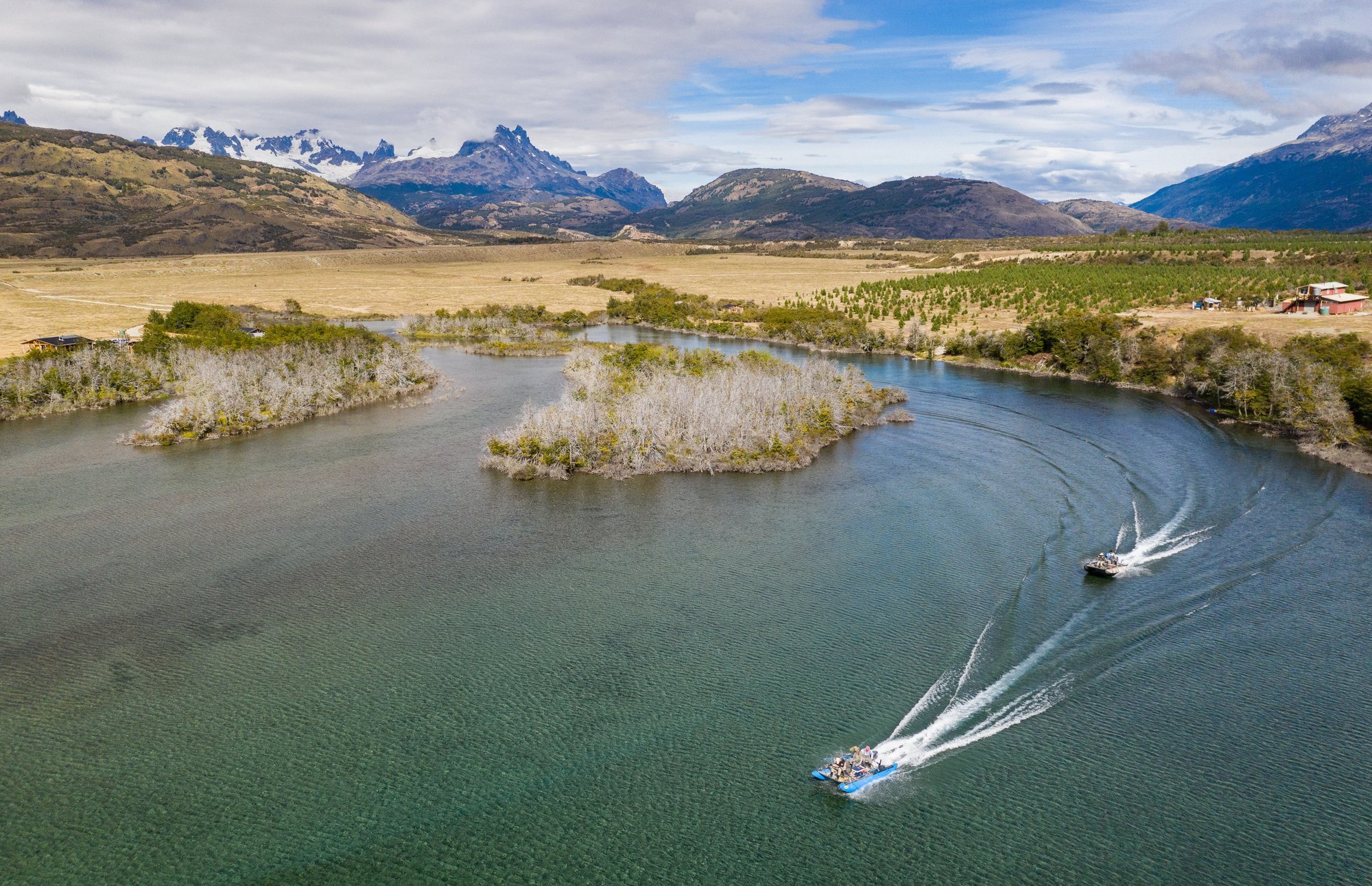 Aerial view of the Río Baker with boats and mountains at Patagonia Baker Lodge