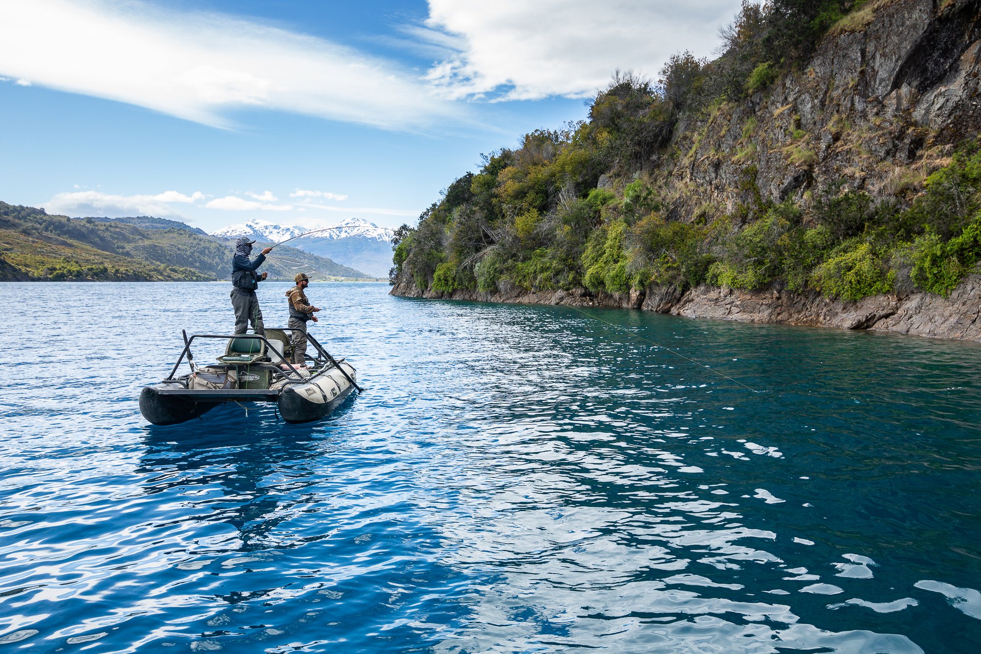 Guests fishing from a drift boat on turquoise Río Baker water