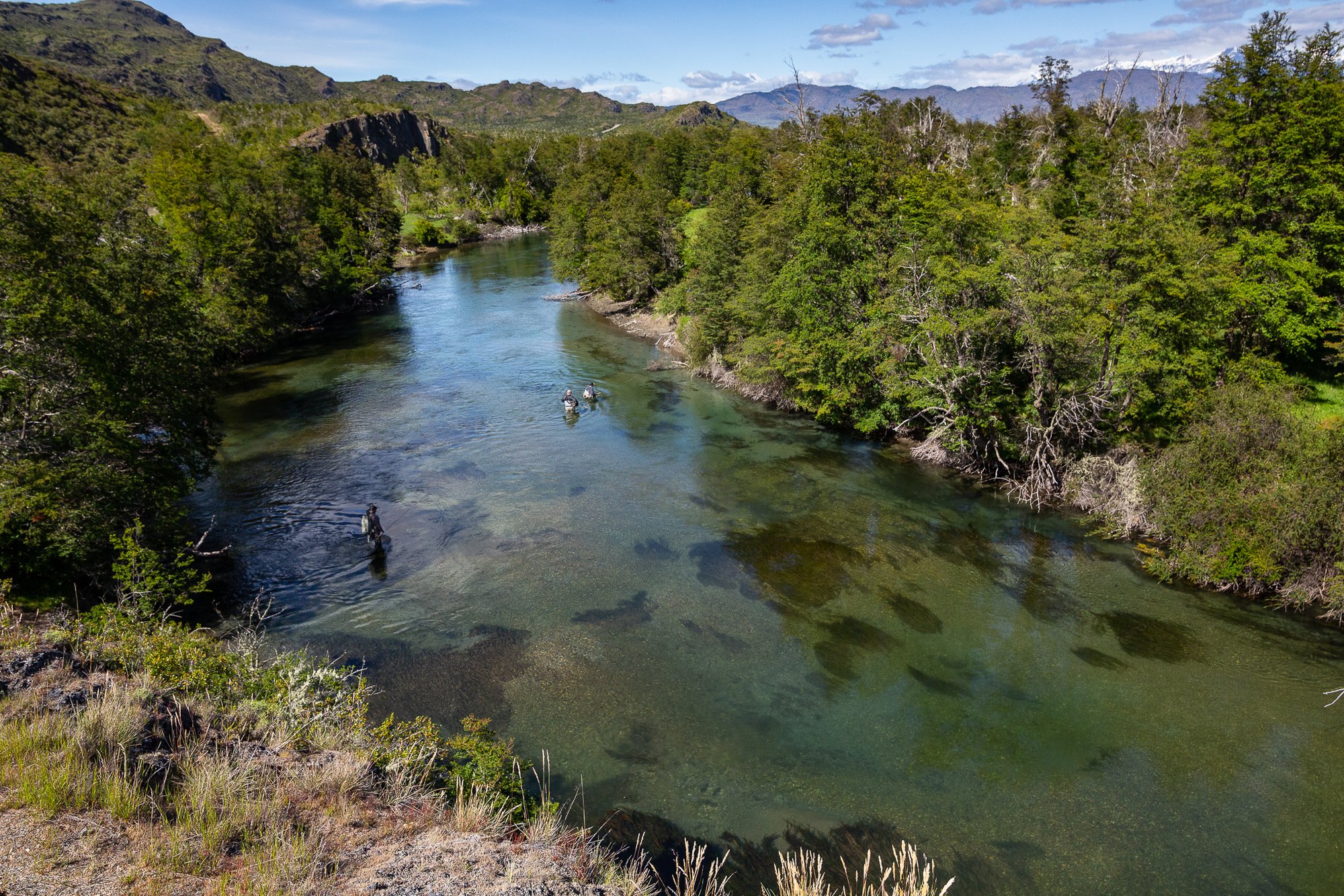 Anglers wade fishing a clear river bend near Patagonia Baker Lodge