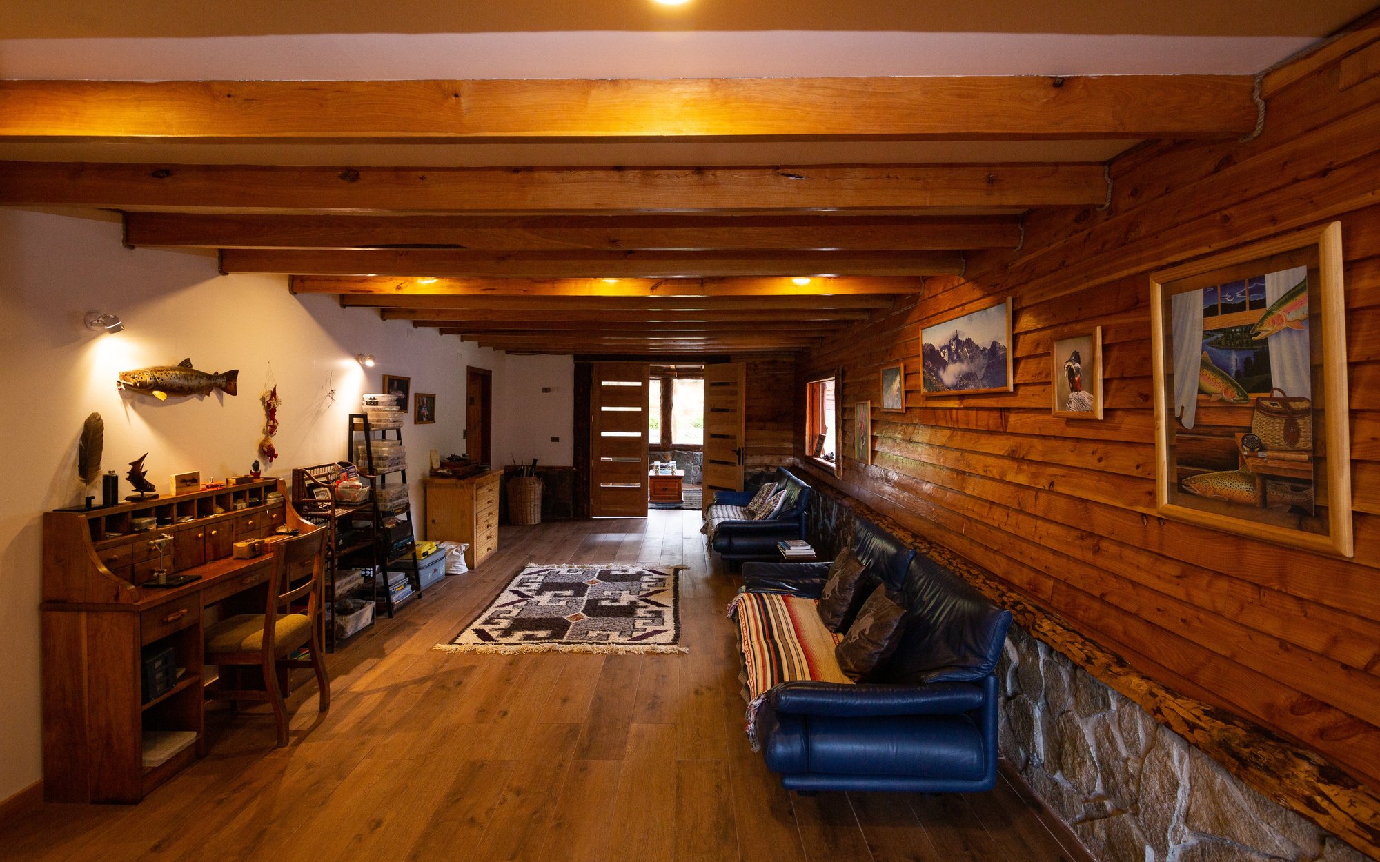 Wood-paneled lounge and fly-tying desk at Magic Waters Lodge near Coyhaique