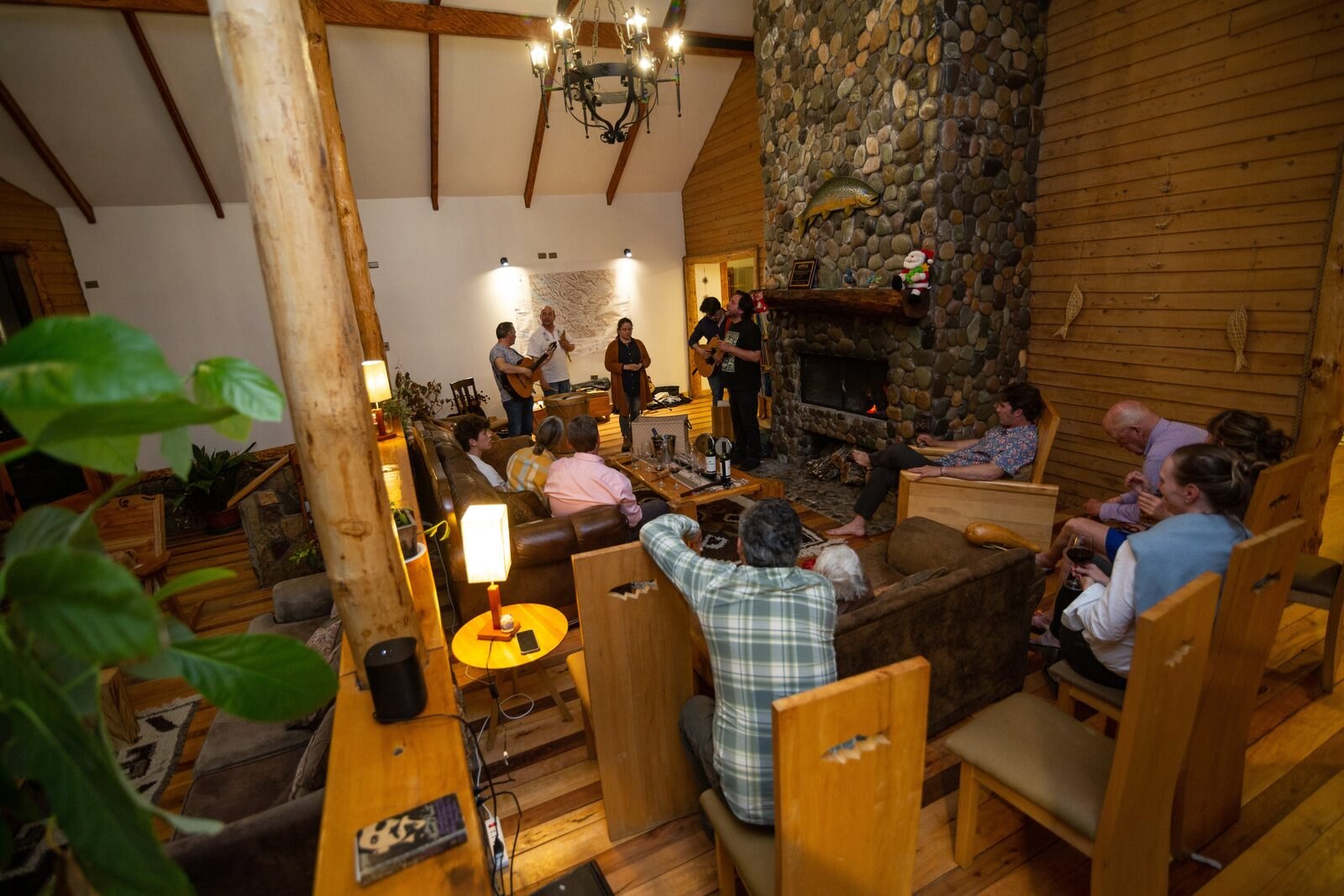 Guests listening to live music by the stone fireplace at Magic Waters Lodge