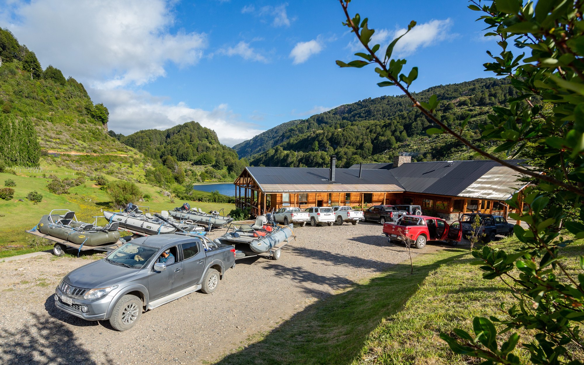 Drift boats and trucks staged at Magic Waters Lodge near Coyhaique