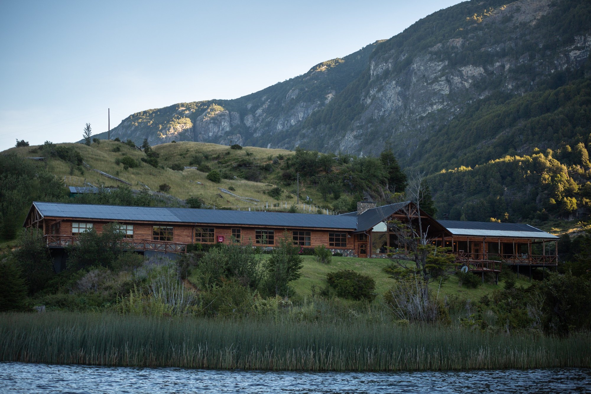Magic Waters Lodge from the water with mountain backdrop near Coyhaique, Chilean Patagonia