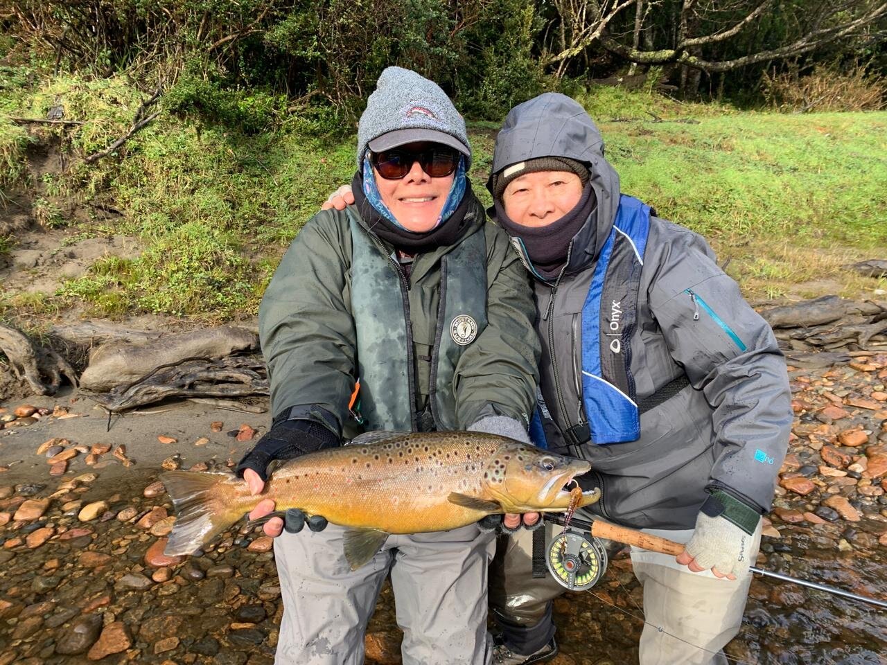 Two guests with a brown trout at River of Dreams Basecamp